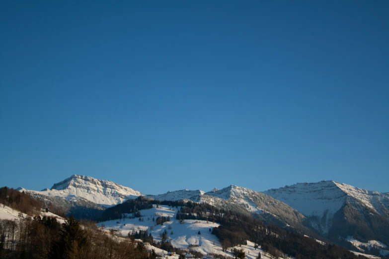 a lone person walks down a snowy mountain ridge