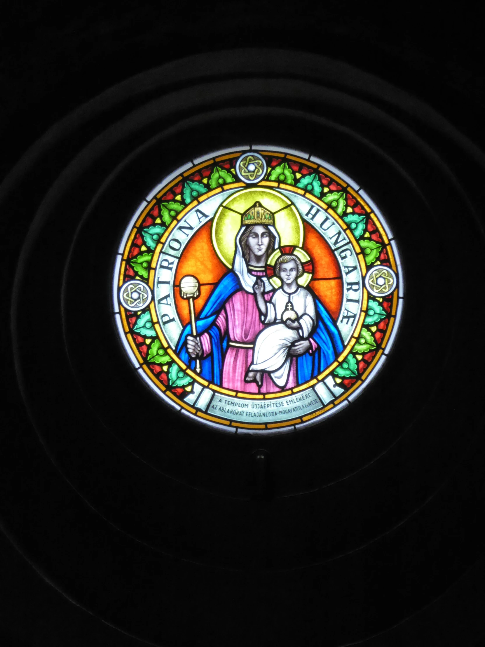 a stain glass with a religious depiction of jesus holding a child