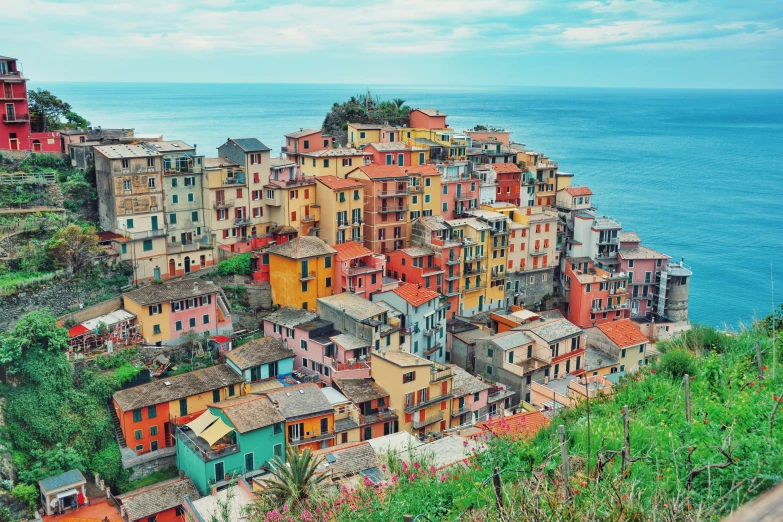 a city on the edge of a mountain with several buildings on top