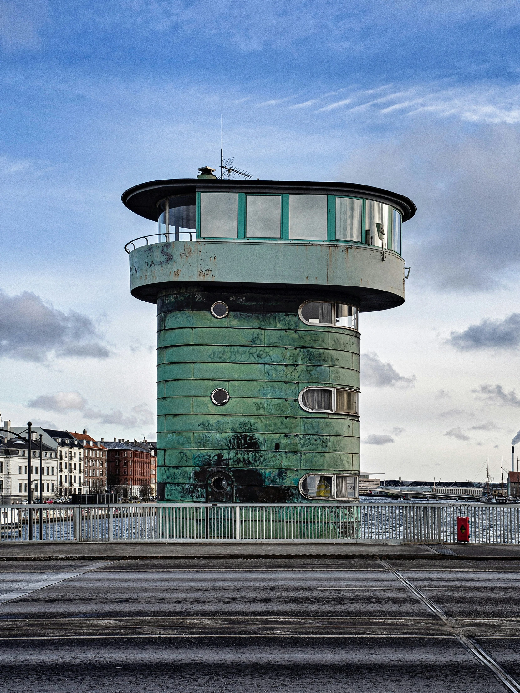 a tall green tower sitting on top of a bridge