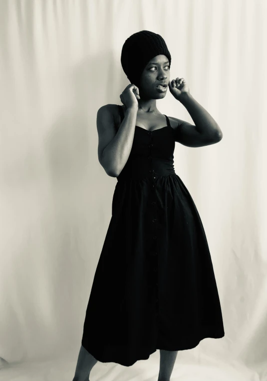 a woman in a short black dress talking on a phone