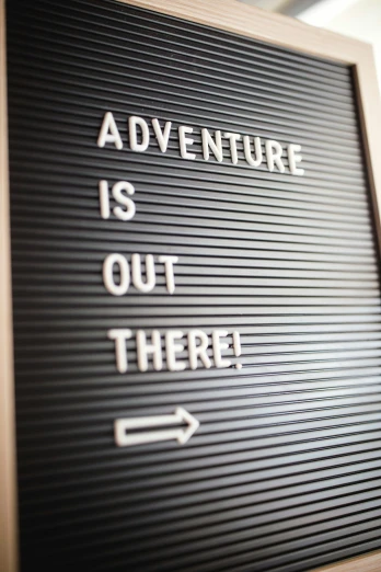 a sign has an arrow on the left and an adventure is out there message on it