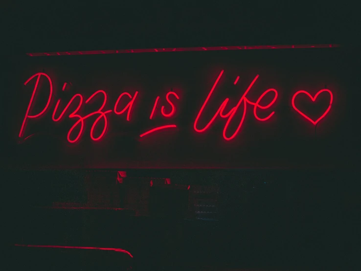 a neon sign reading pizzas is life with hearts