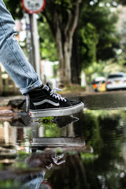 a person wearing black shoes stepping on a dle in the road