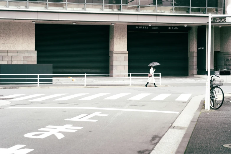 an open door and parking garage with someone walking with their bike