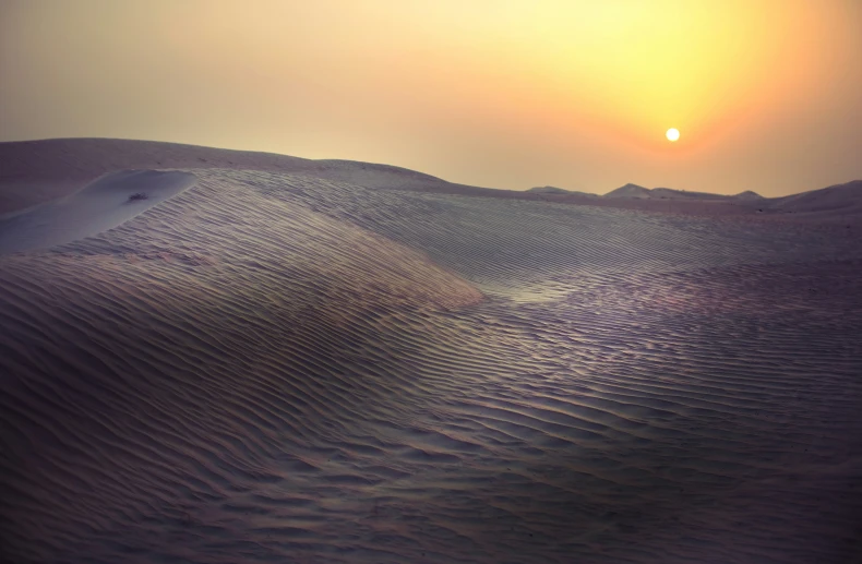 the sun setting over a desert at twilight