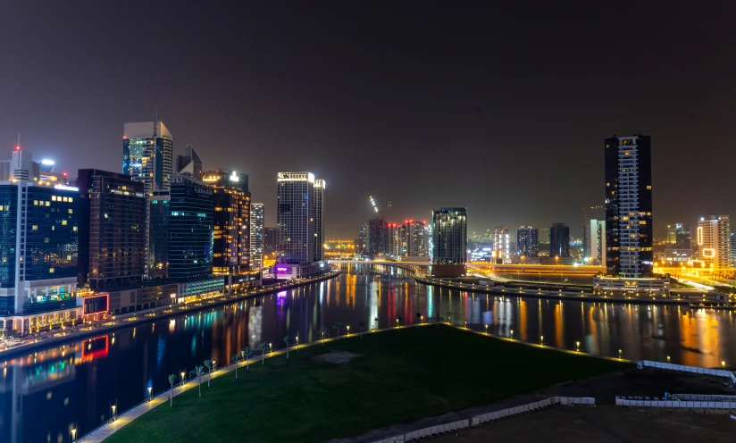 a skyline view of a city skyline, some lights reflecting off the water