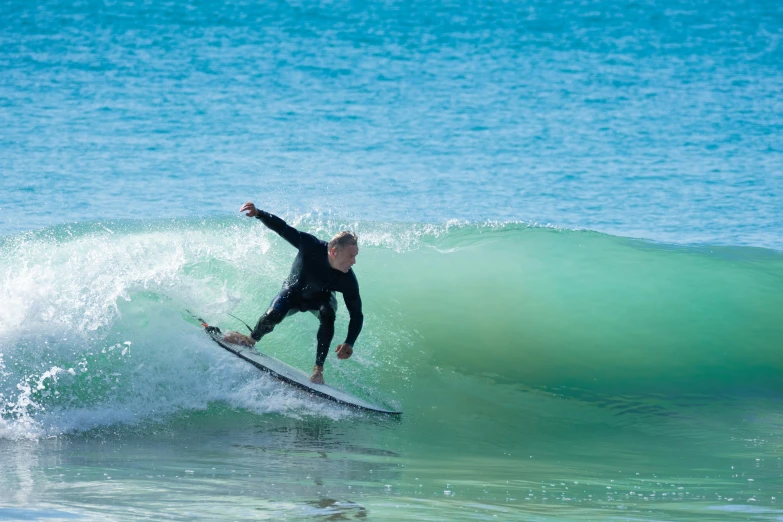 a man riding on top of a wave on a surfboard