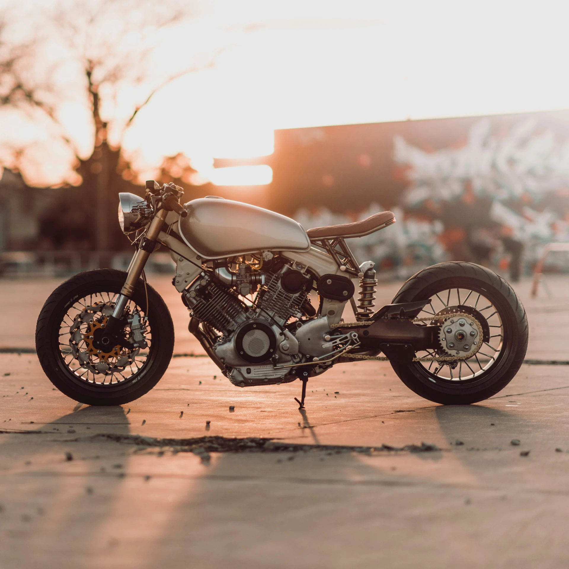 the motorcycle is parked on the street next to the trees