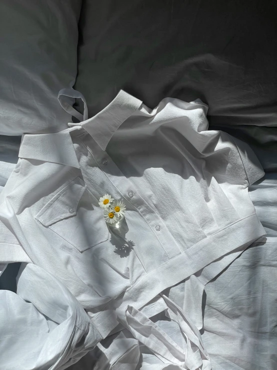 there is a flower that is on top of the bed sheet