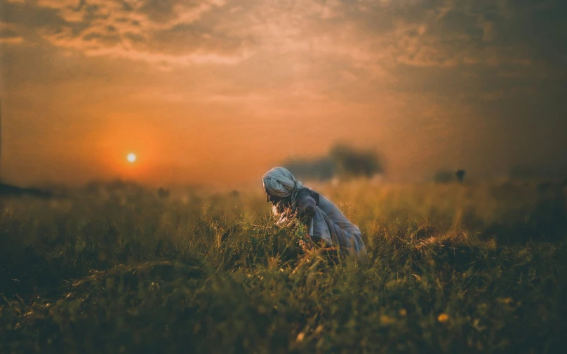 a person standing in tall grass with a sky in the background