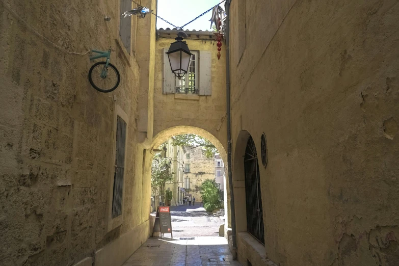 a narrow alley with a clock and a bicycle