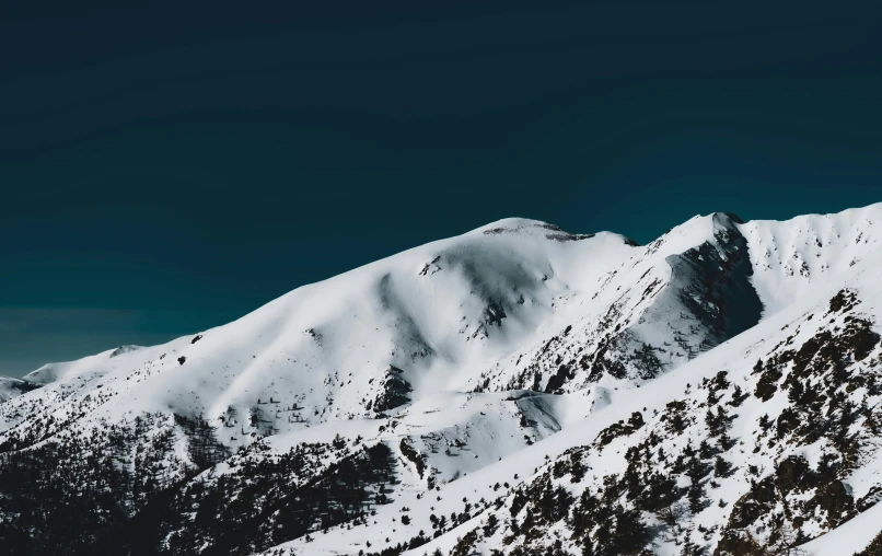 a snowy mountain is seen from above, on a clear day