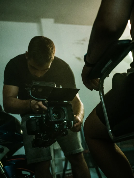 a guy that is sitting down with some cameras