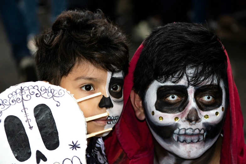 two children wearing costumes and painted faces