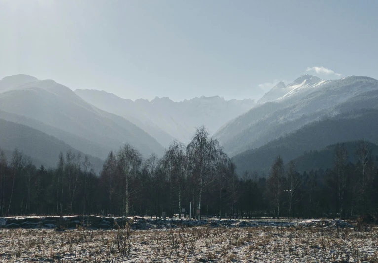 the mountain range is covered with snow in the distance