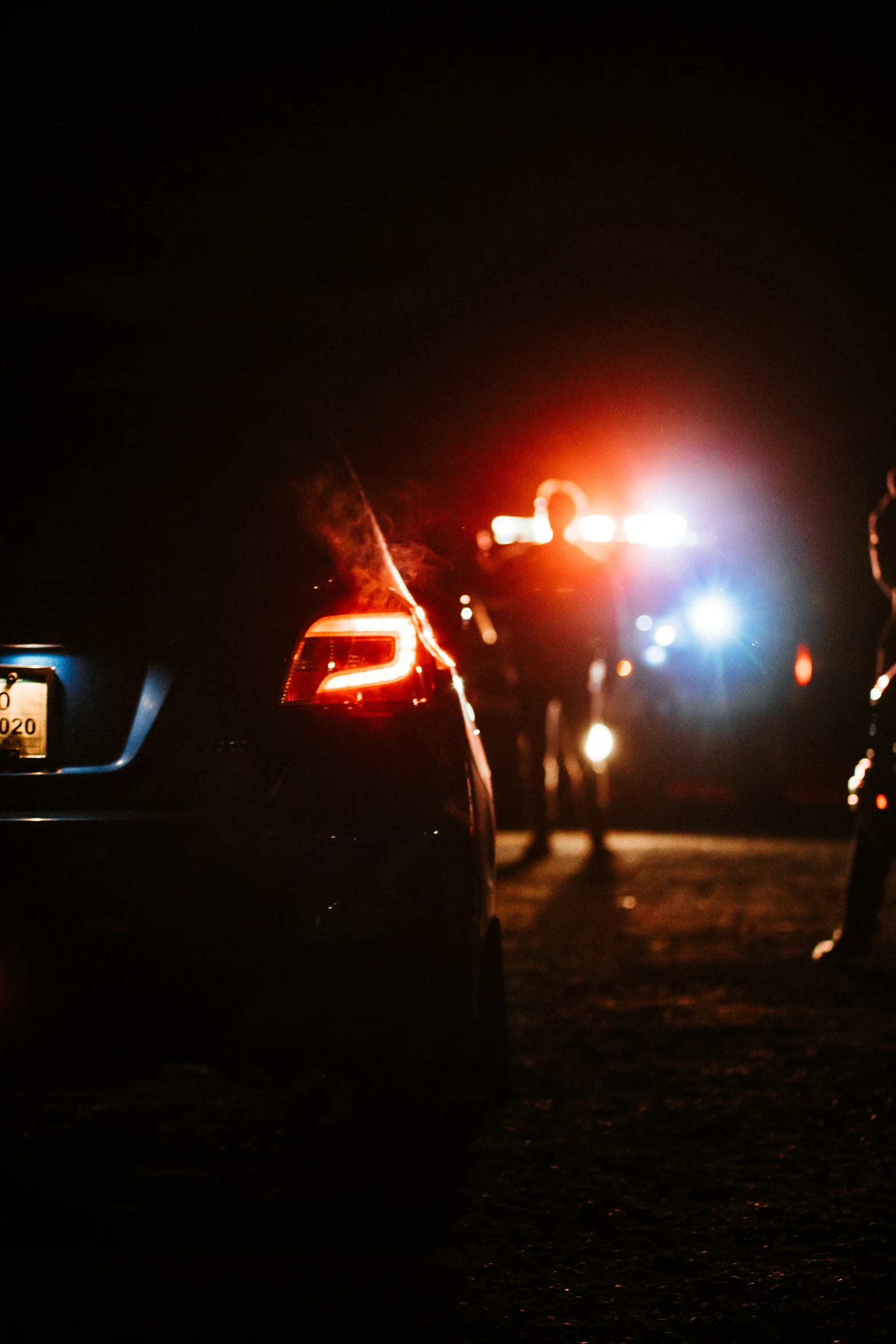 three police cars parked by the street at night