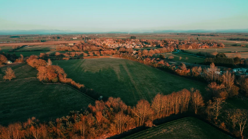 an aerial view of a town with trees and green grass