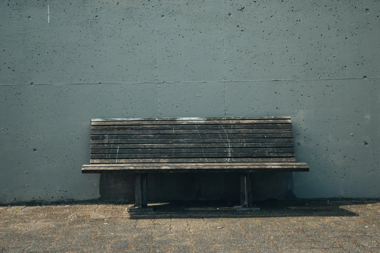 a wooden bench sits against a blue wall