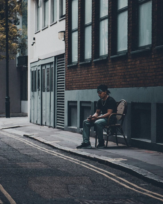 a person sitting in a chair in front of a building