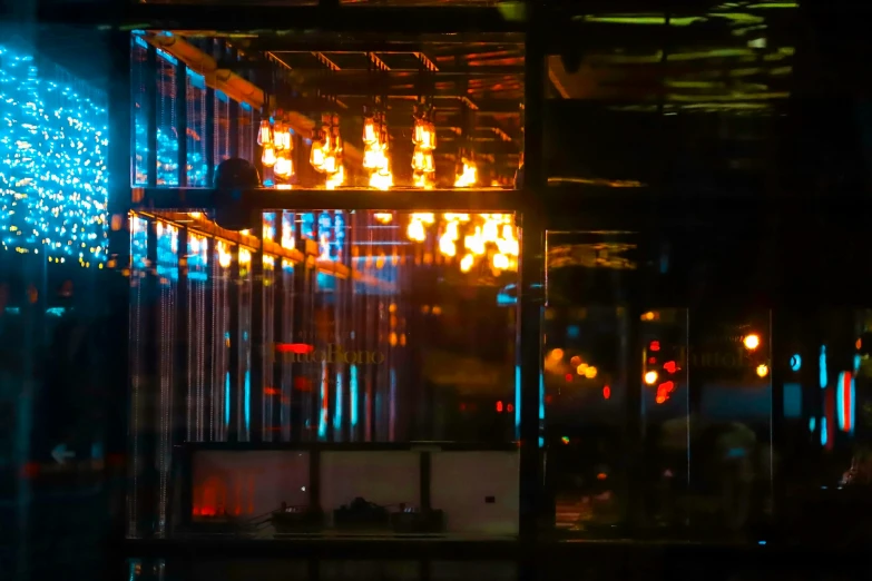 a neon display behind some glass and a man walking