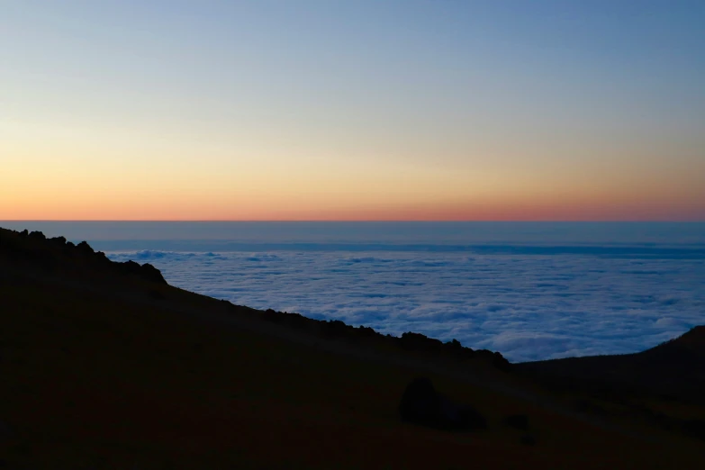 a person with their feet up on a hill above the clouds