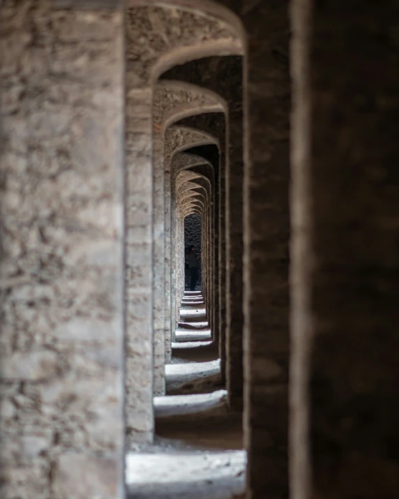 stone tunnel with lights on them and a person on the ground