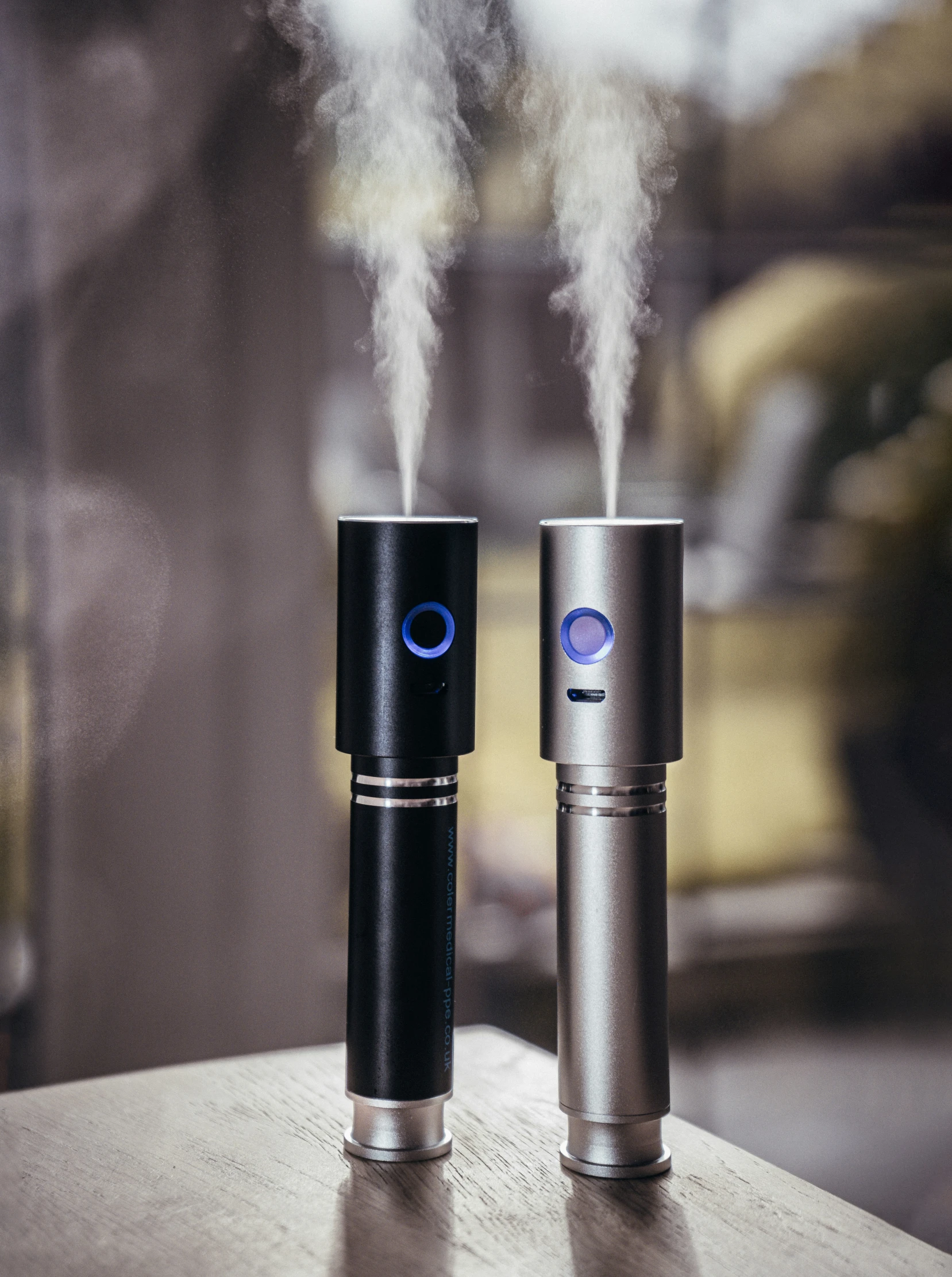 two vapor mist machines side by side with smoke coming out