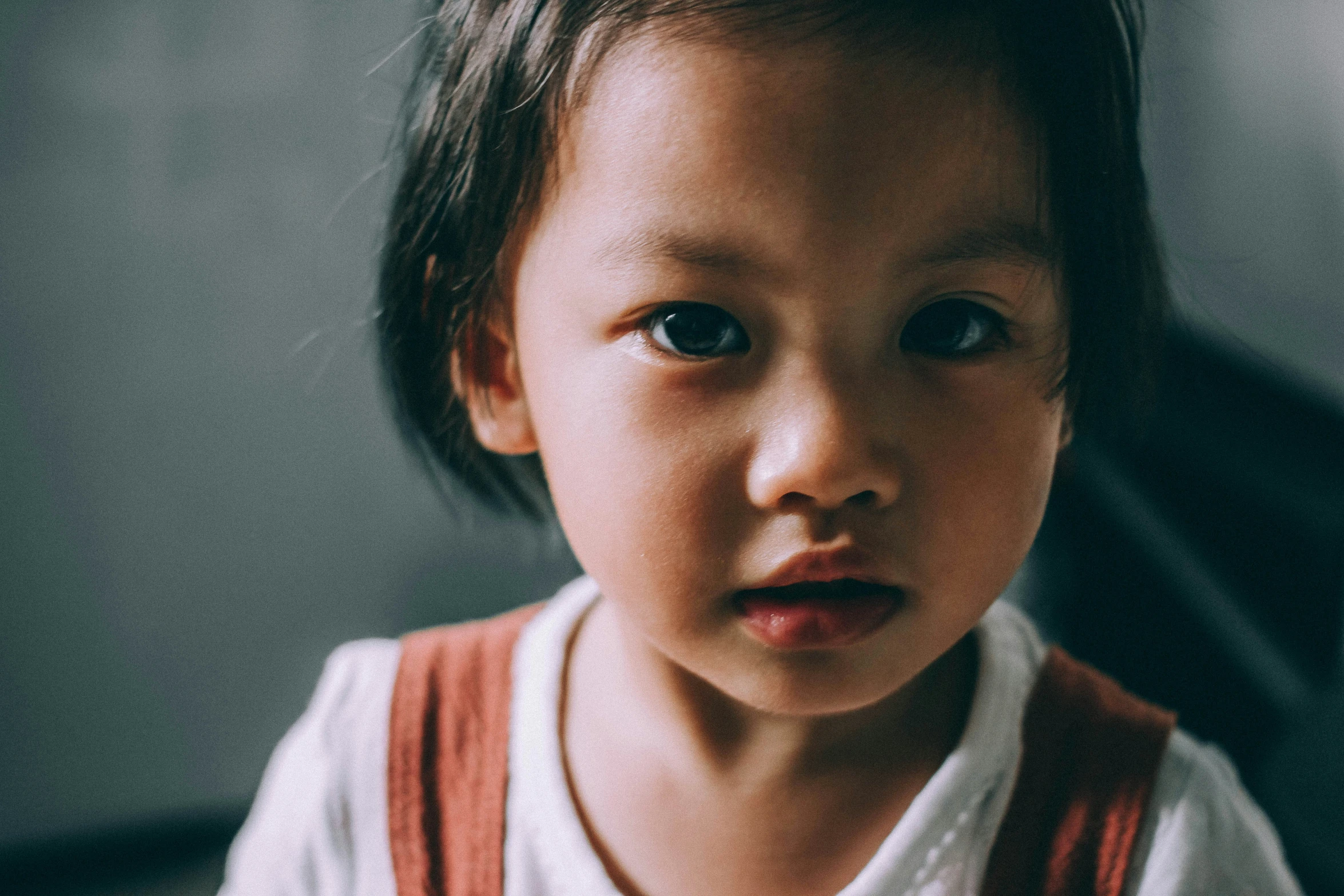 a close up view of a toddler, with an intense look