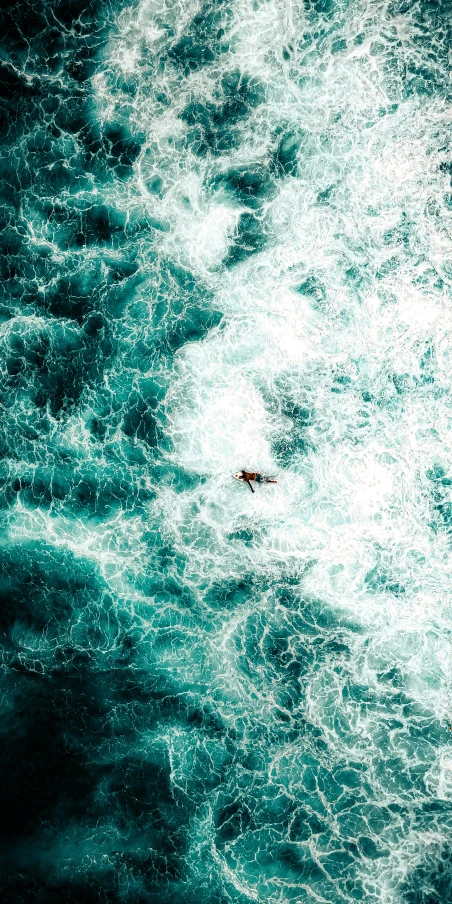 an overhead view of some water and a lone boat