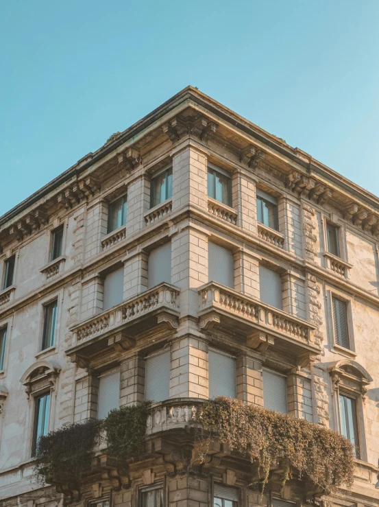 an old building with an arched balconies and plants growing up the side