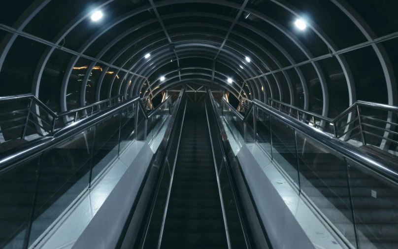 an empty escalator in a subway station at night