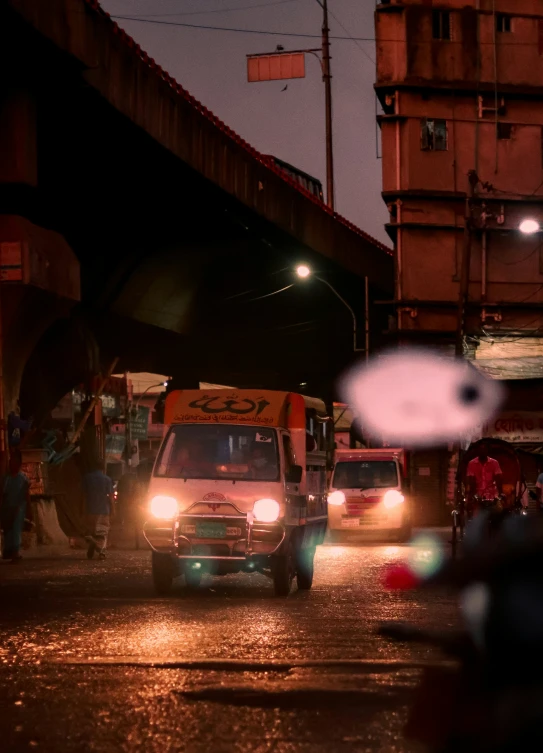 an ambulance is parked by the street on a rainy evening