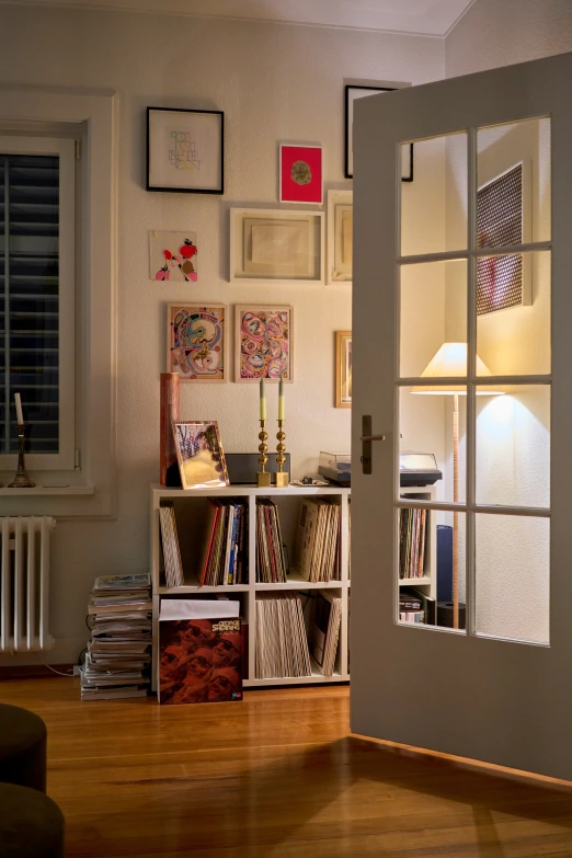 an entry way with pictures, drawers and a lamp on