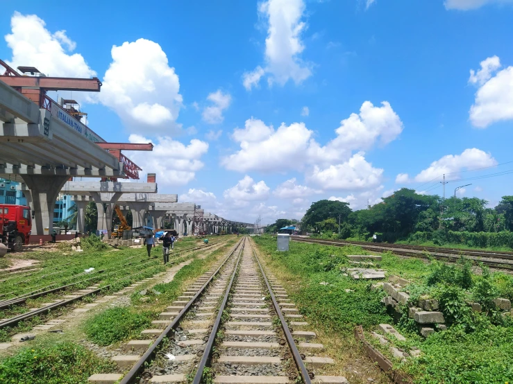 people are walking down a train track that is empty