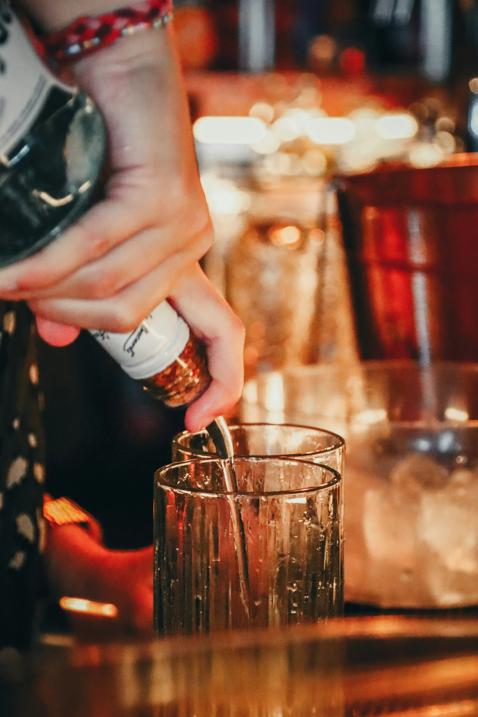 bartender adding an item to a s in front of a wineglass