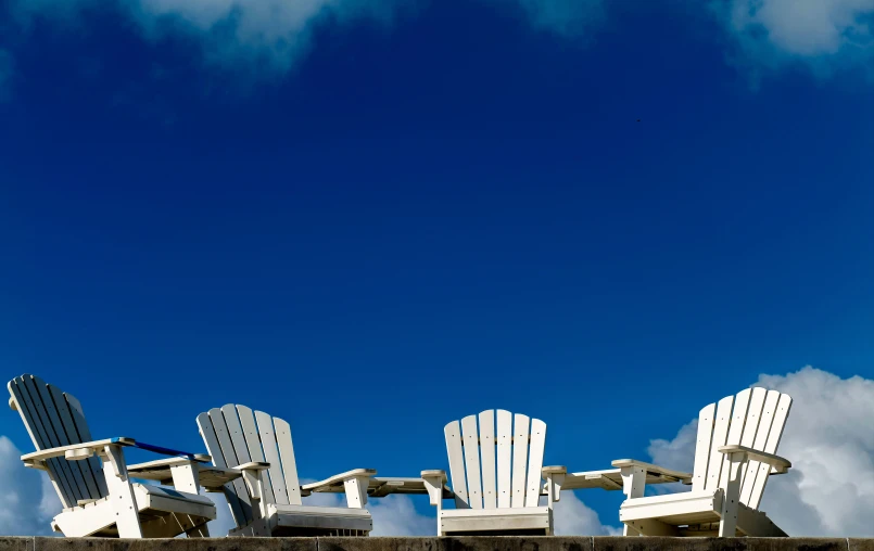 a couple of lawn chairs sitting on top of a concrete wall