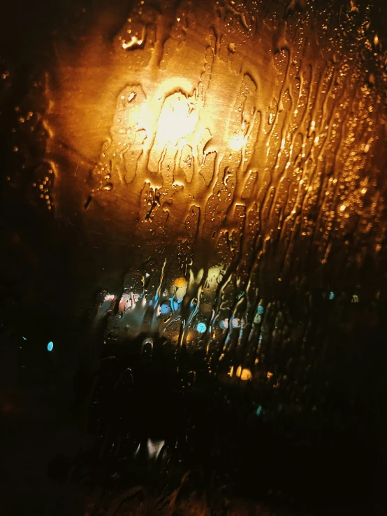 a streetlight in the rain with a dark background