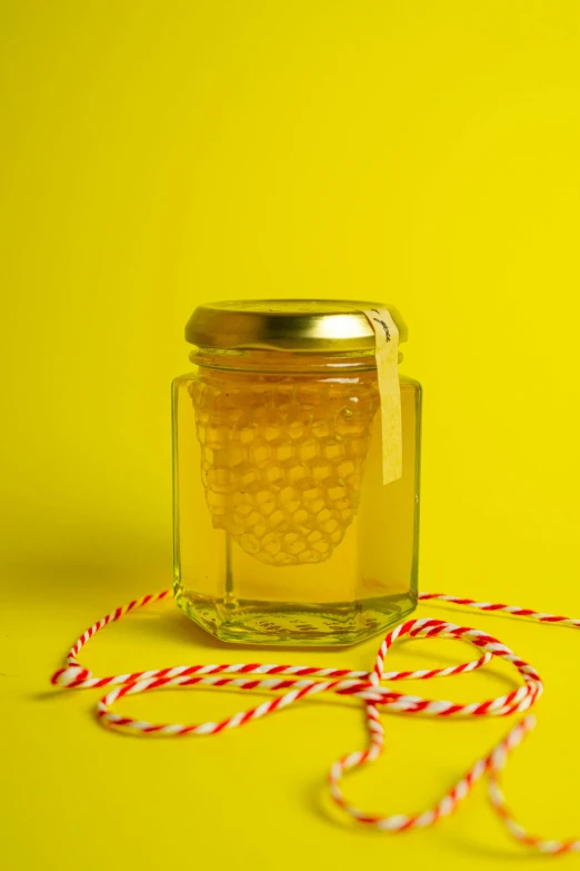 a small jar with honey inside surrounded by candy canes