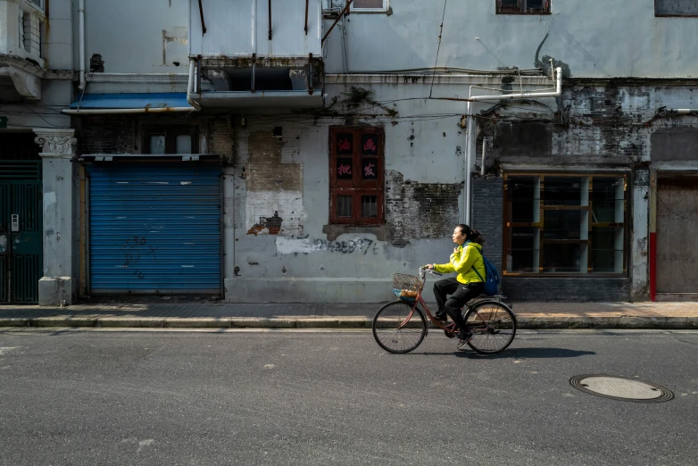 a man riding on the back of a bike down a street