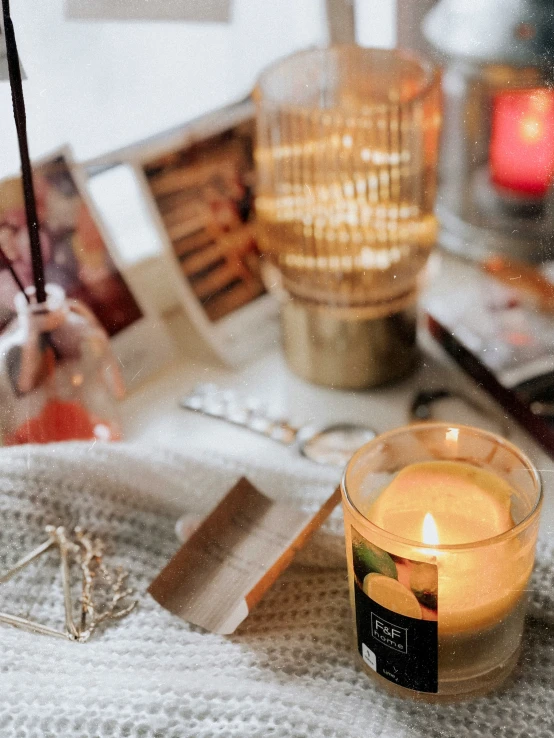 a candle in a small glass near some books