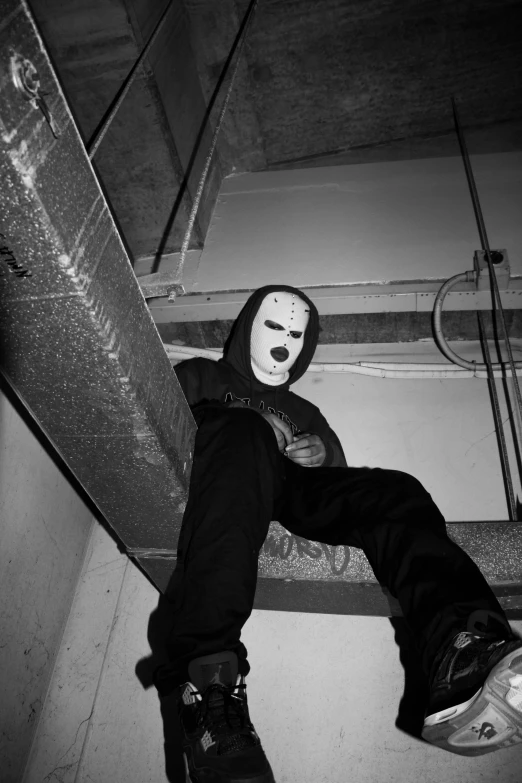 a person with their foot on a rail wearing a mask