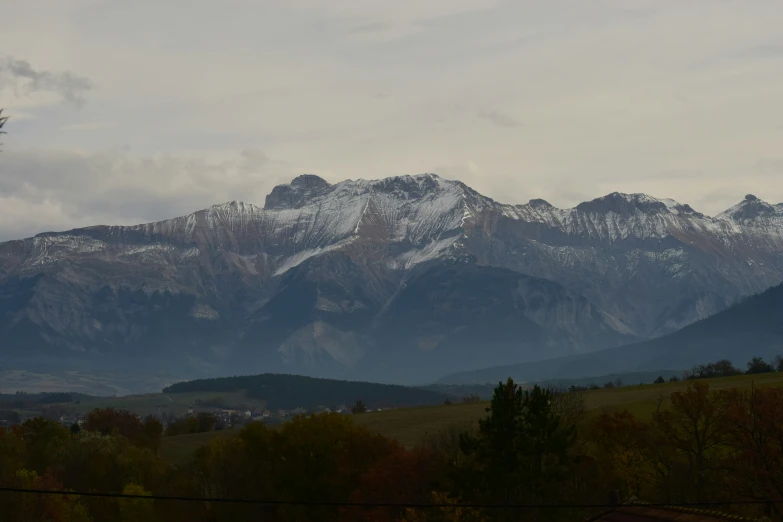 a snow covered mountain view with trees in the foreground