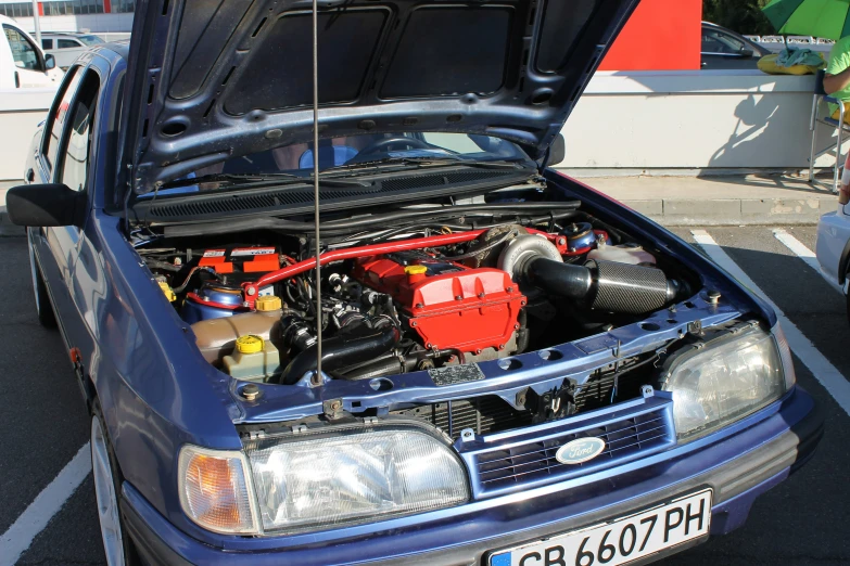 a blue car with the hood open showing it's engine