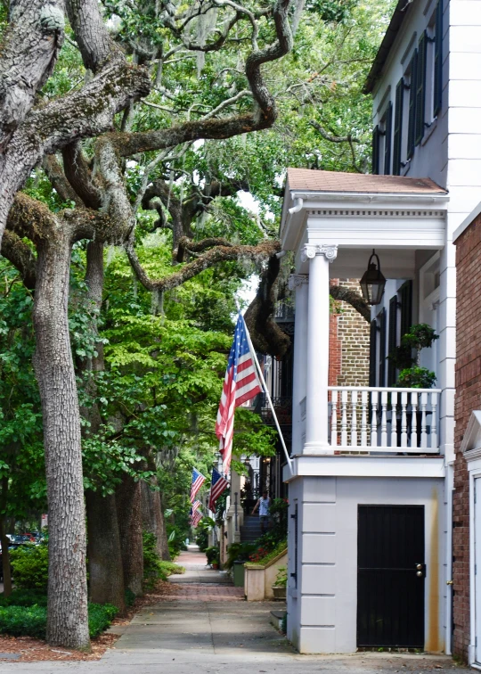 a white house with a american flag on it's balcony