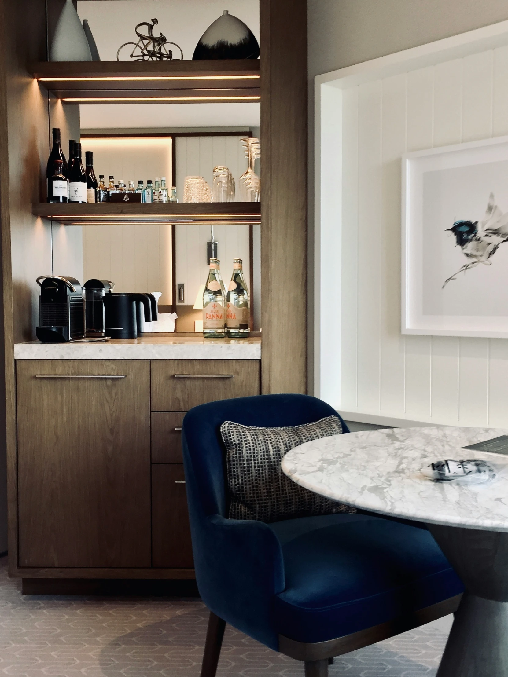 a wine bar with built in cabinets and a marble dining table