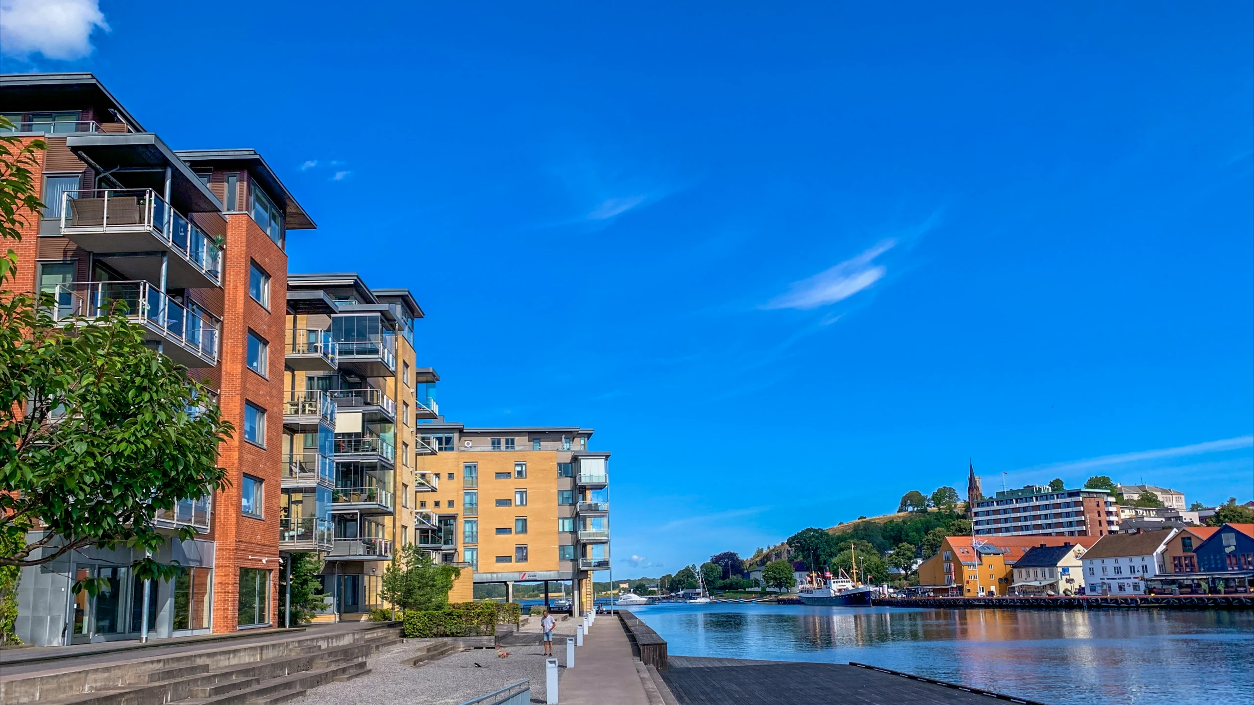 two large buildings are shown on the bank of a lake