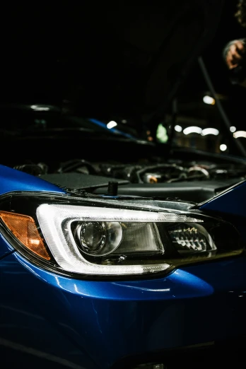 close up of a blue car headlight in front of other cars