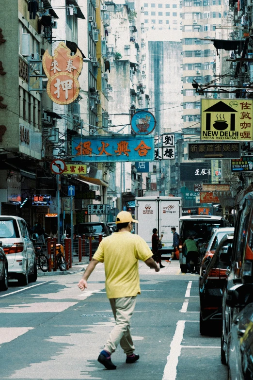 an asian man walking across a city street