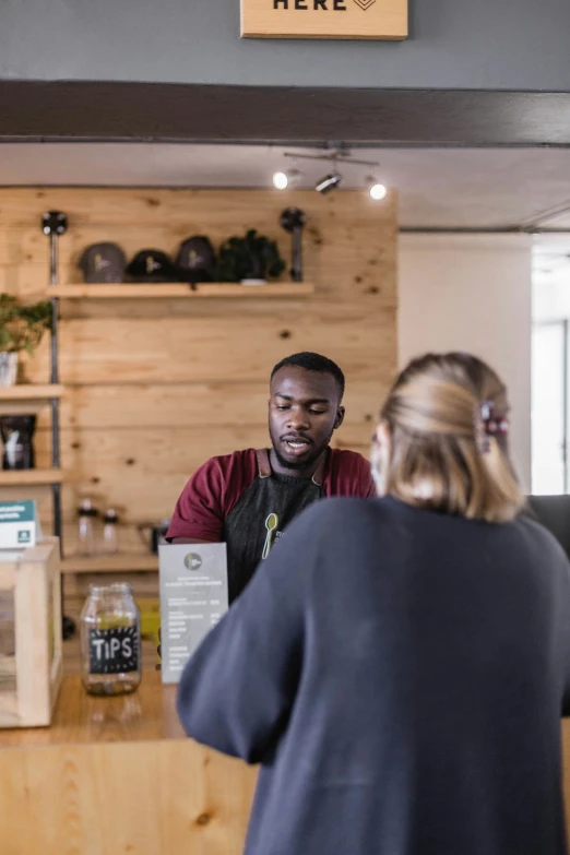 a man standing behind a customer in a counter